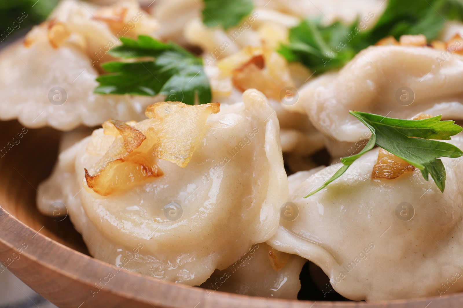 Photo of Delicious dumplings (varenyky) with potatoes, onion and parsley on plate, closeup