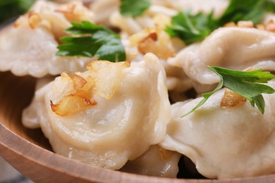 Photo of Delicious dumplings (varenyky) with potatoes, onion and parsley on plate, closeup