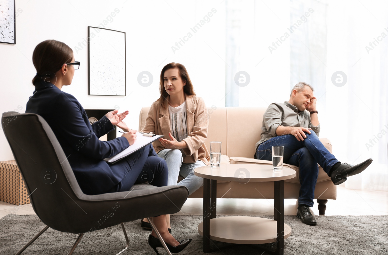 Photo of Psychotherapist working with couple in office. Family counselling