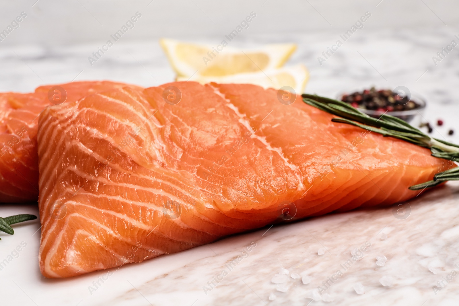Photo of Marble board with tasty salmon fillet on table, closeup