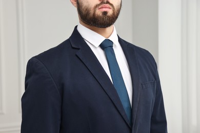 Photo of Businessman in suit and necktie indoors, closeup