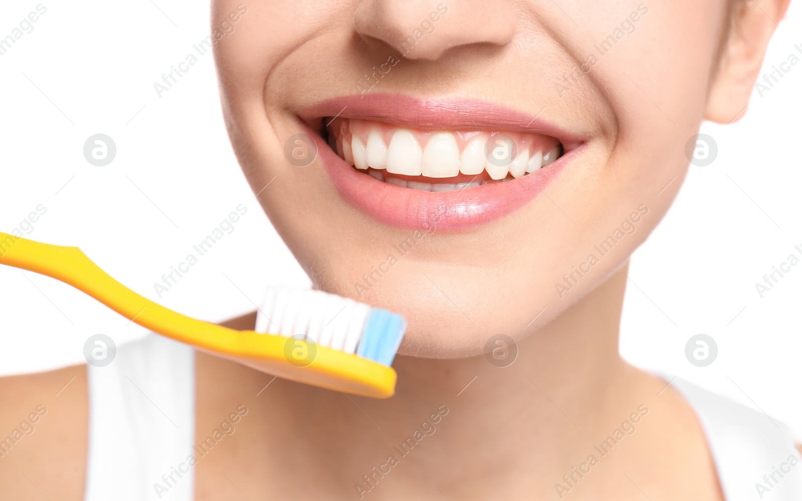 Photo of Young woman brushing her teeth on white background, closeup