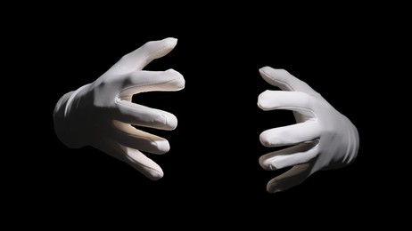 Photo of Magician holding something on black background, closeup