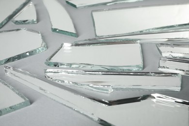 Photo of Shards of broken mirror on white background, closeup view