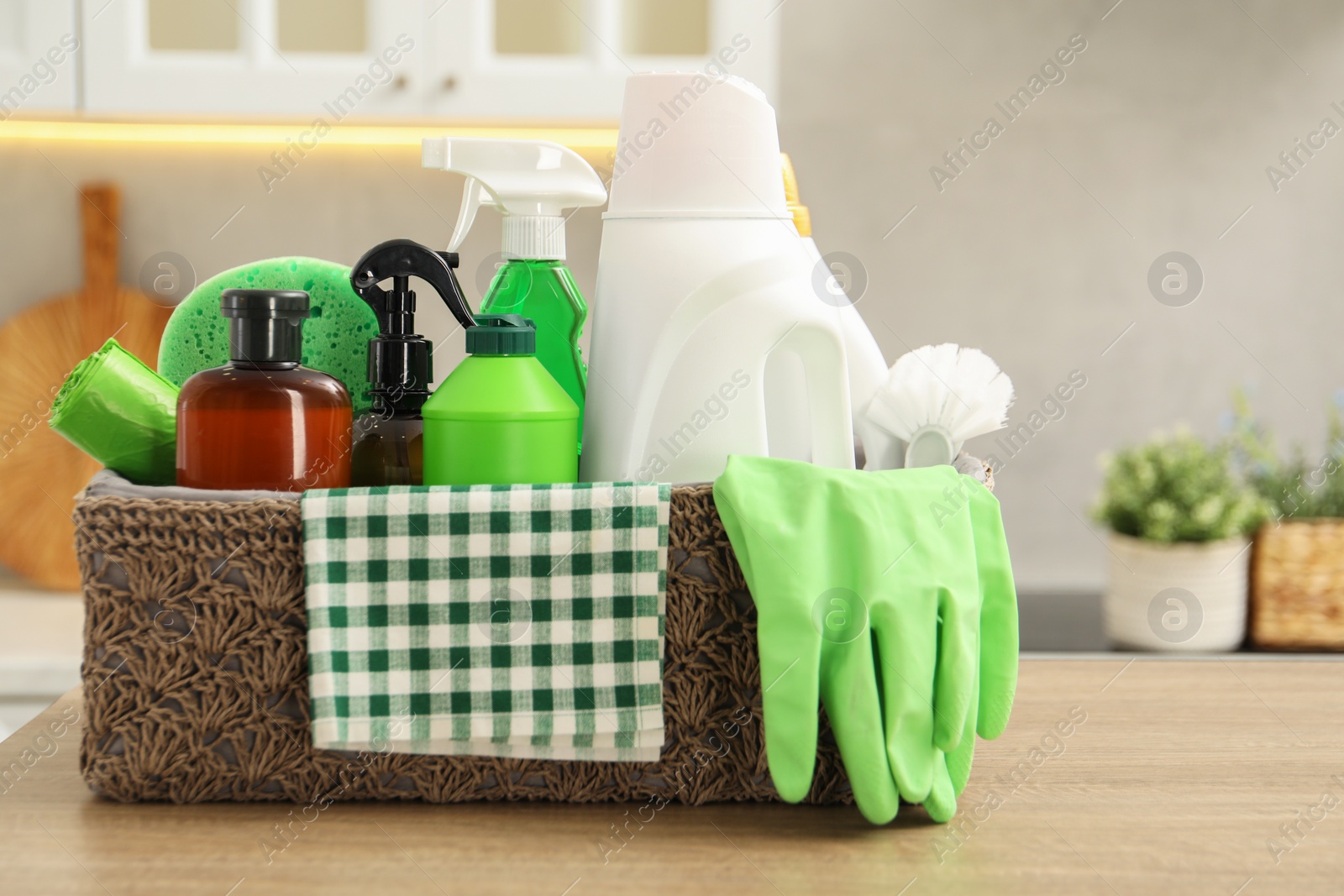 Photo of Different cleaning supplies in basket on table