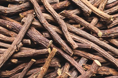 Photo of Dried sticks of liquorice root as background, top view