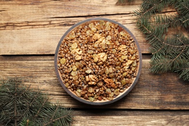 Traditional Christmas slavic dish kutia and fir branches on wooden table, flat lay