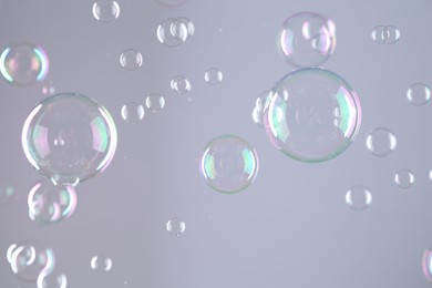 Beautiful transparent soap bubbles on grey background