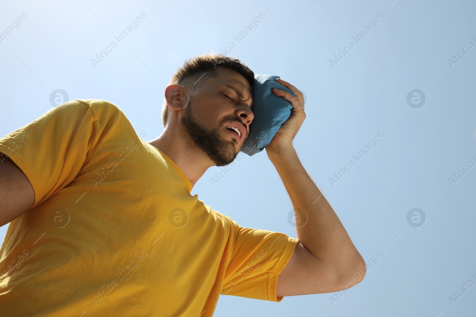 Photo of Man with cold pack suffering from heat stroke outdoors