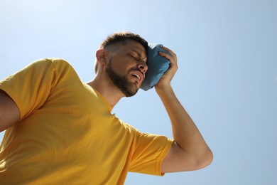 Photo of Man with cold pack suffering from heat stroke outdoors