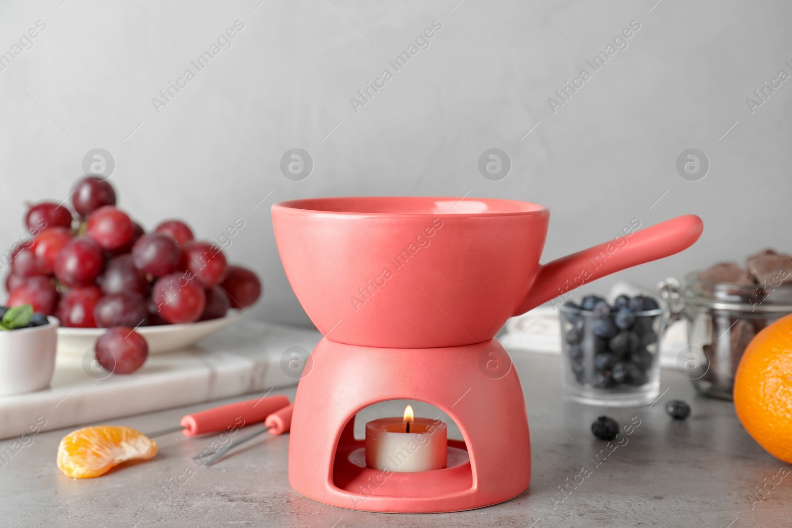 Photo of Ceramic fondue pot with candle on table