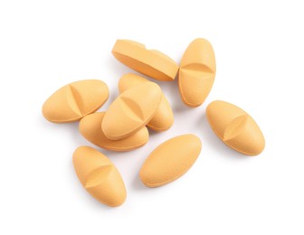 Photo of Many orange pills isolated on white, top view