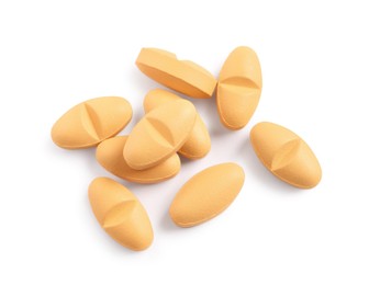 Many orange pills isolated on white, top view