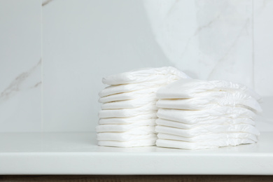 Stacks of baby diapers on counter in bathroom