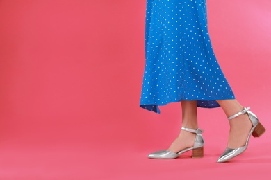 Photo of Woman in stylish shoes on pink background. Space for text