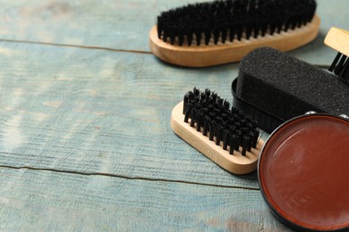 Photo of Composition with shoe care accessories on wooden background, closeup. Space for text