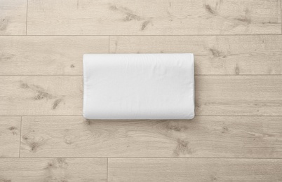 Photo of Clean soft bed pillow on wooden background, top view