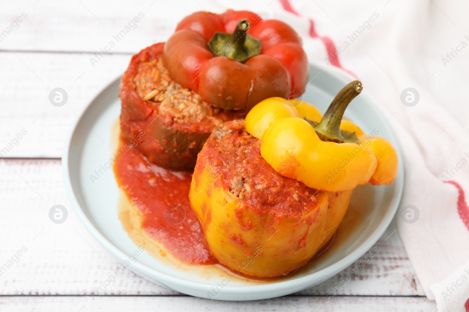 Photo of Delicious stuffed bell peppers on white wooden table, closeup