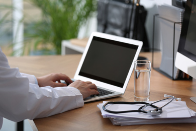 Photo of Professional doctor working on laptop in office, closeup