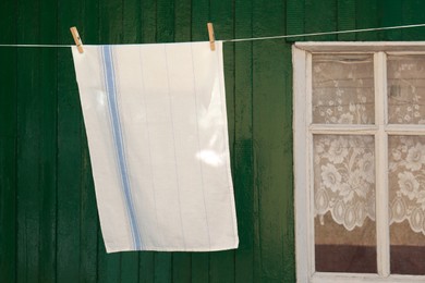 Photo of Washing line with clean laundry and clothespins outdoors
