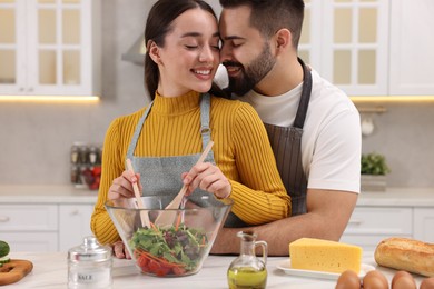 Lovely young couple cooking together in kitchen