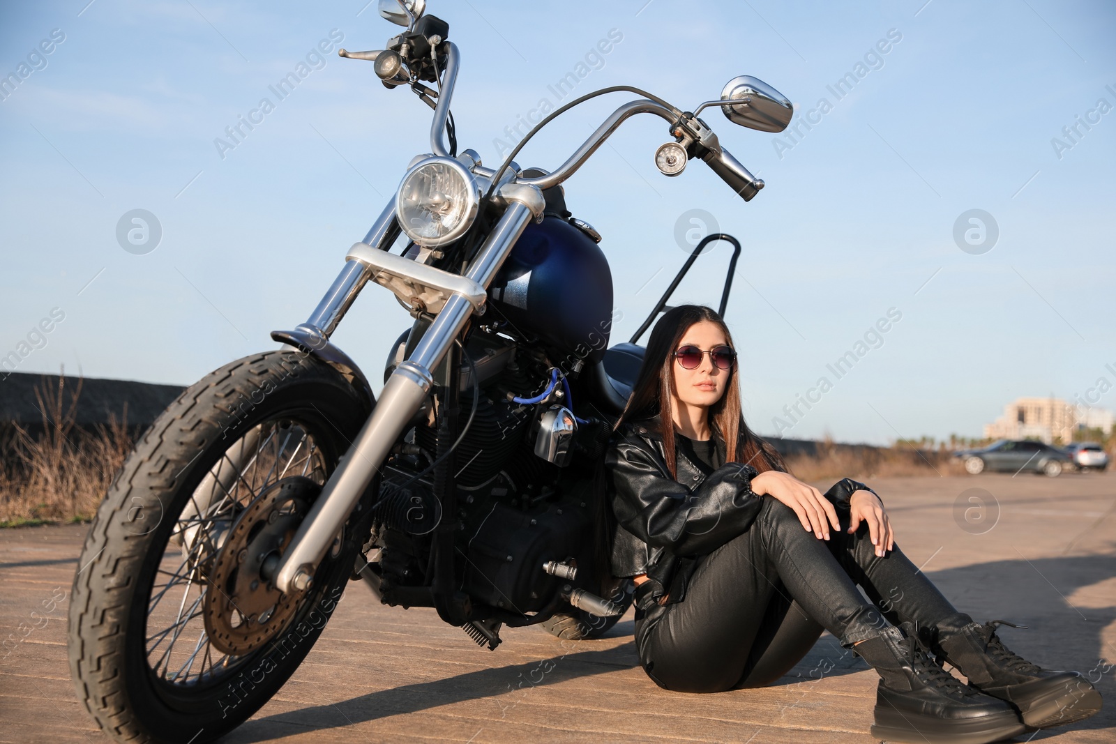 Photo of Beautiful woman sitting near motorcycle on sunny day