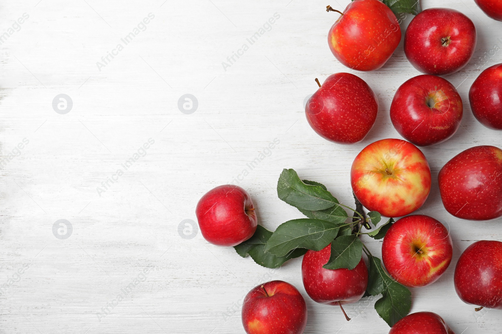 Photo of Many juicy red apples and space for text on wooden background, top view