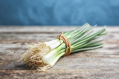 Photo of Tied fresh green onion on wooden table