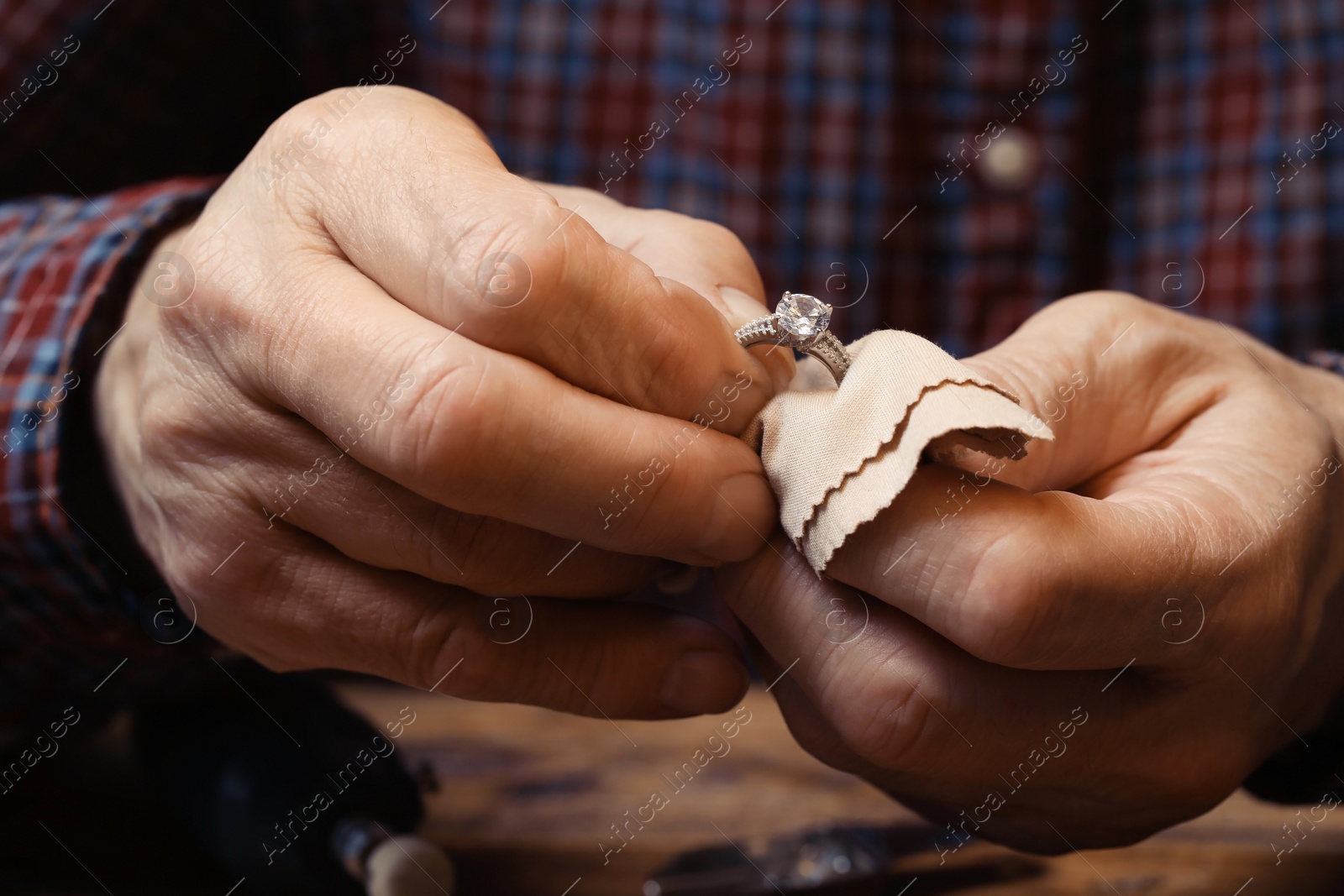 Photo of Professional jeweler working with ring, closeup view