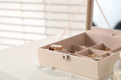 Photo of Jewelry box with many different accessories on white table, closeup. Space for text