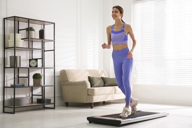 Sporty woman training on walking treadmill at home