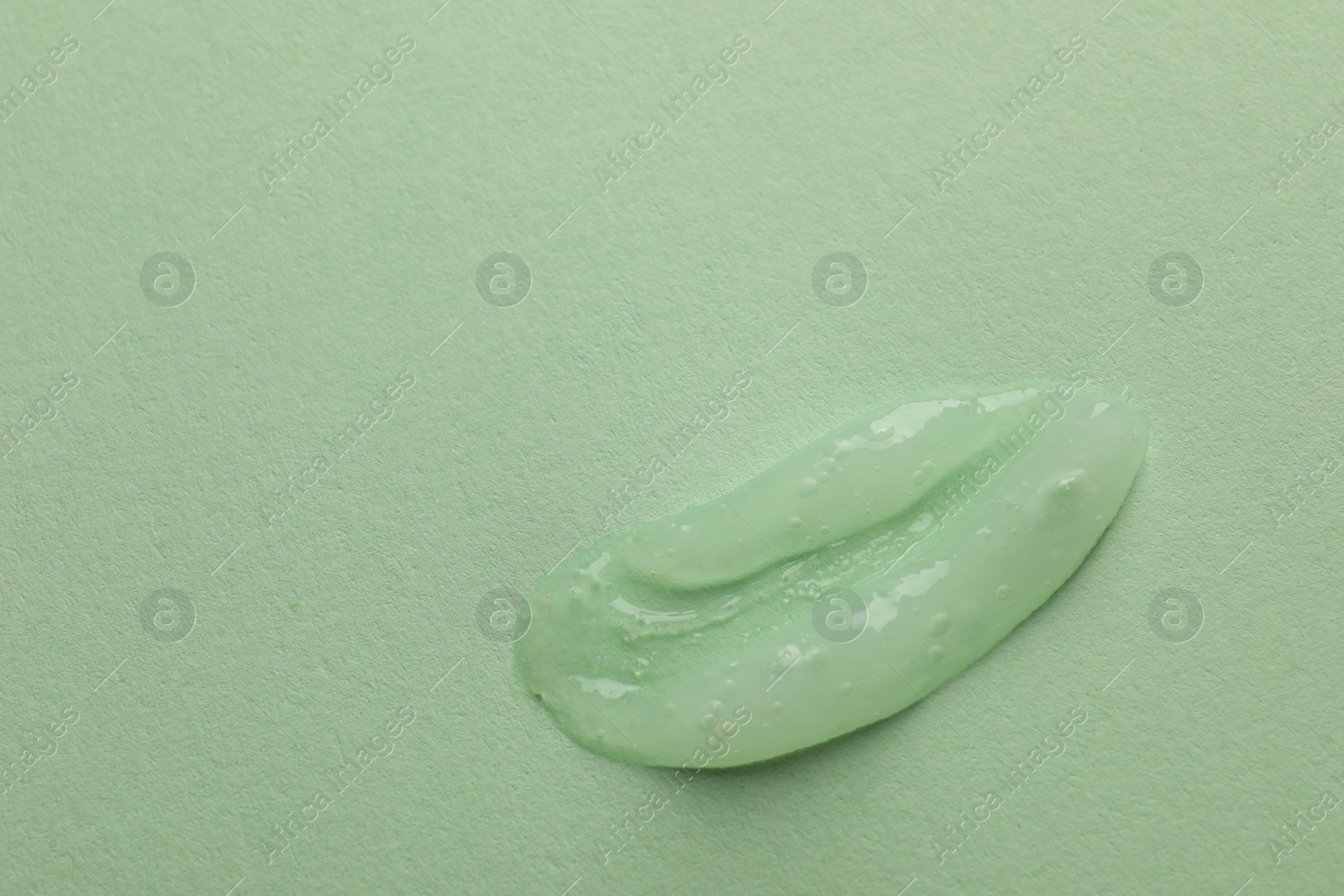 Photo of Sample of face gel on light green background, top view. Space for text