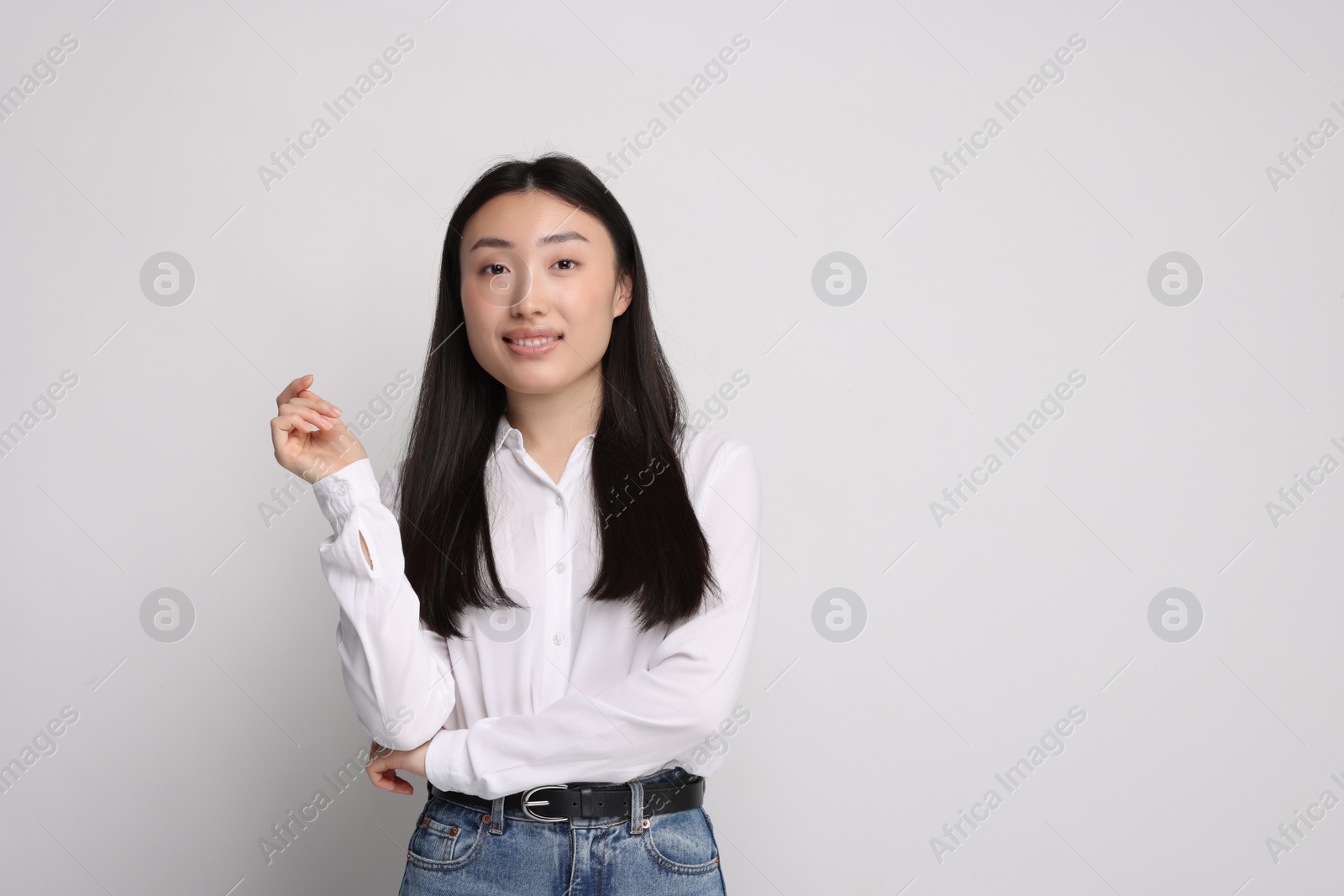 Photo of Portrait of smiling woman on light background. Space for text