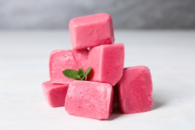 Tasty berry ice cubes on light table