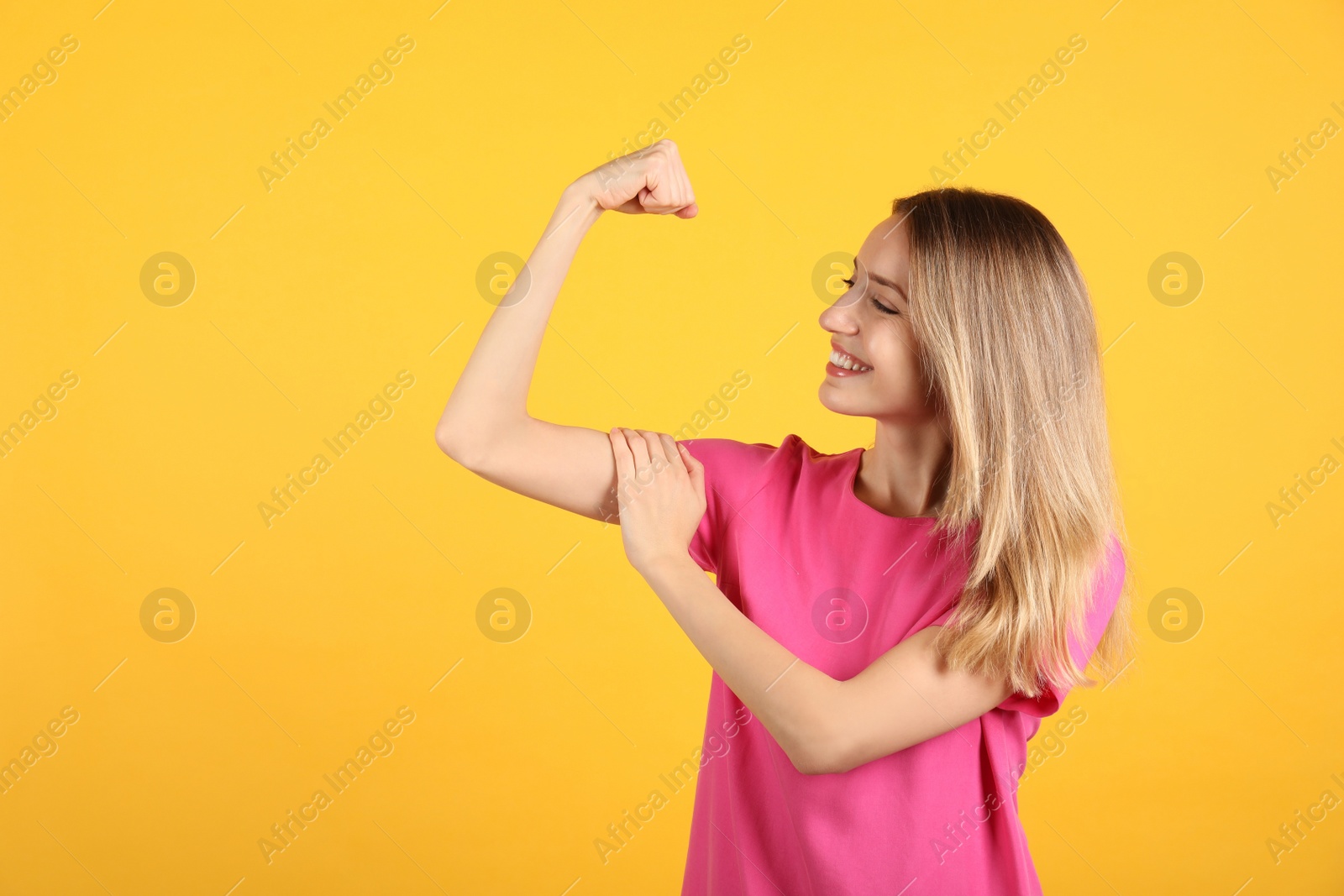 Photo of Strong woman as symbol of girl power on yellow background, space for text. 8 March concept