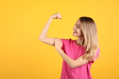 Strong woman as symbol of girl power on yellow background, space for text. 8 March concept