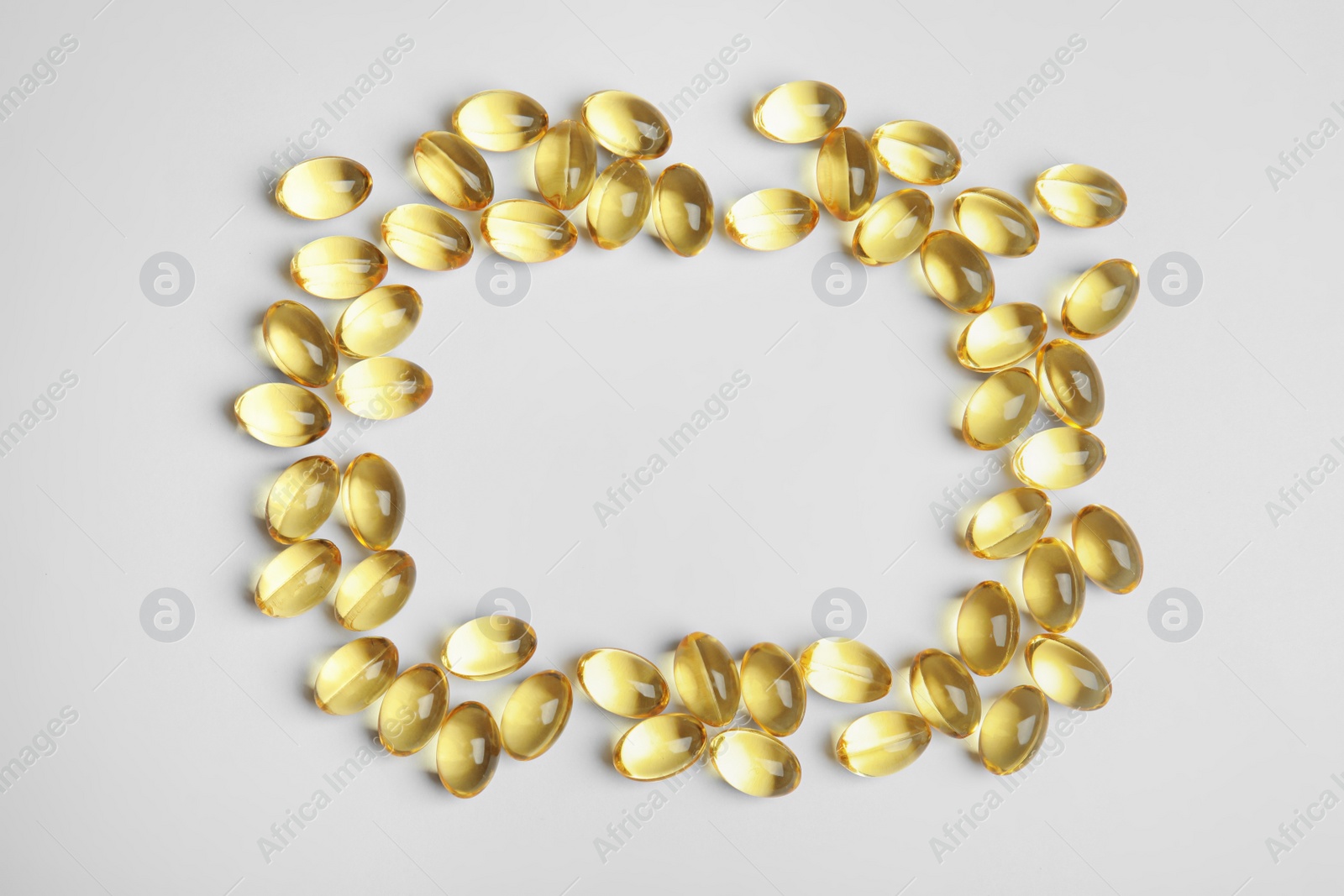 Photo of Frame of cod liver oil pills with space for text on white background, top view