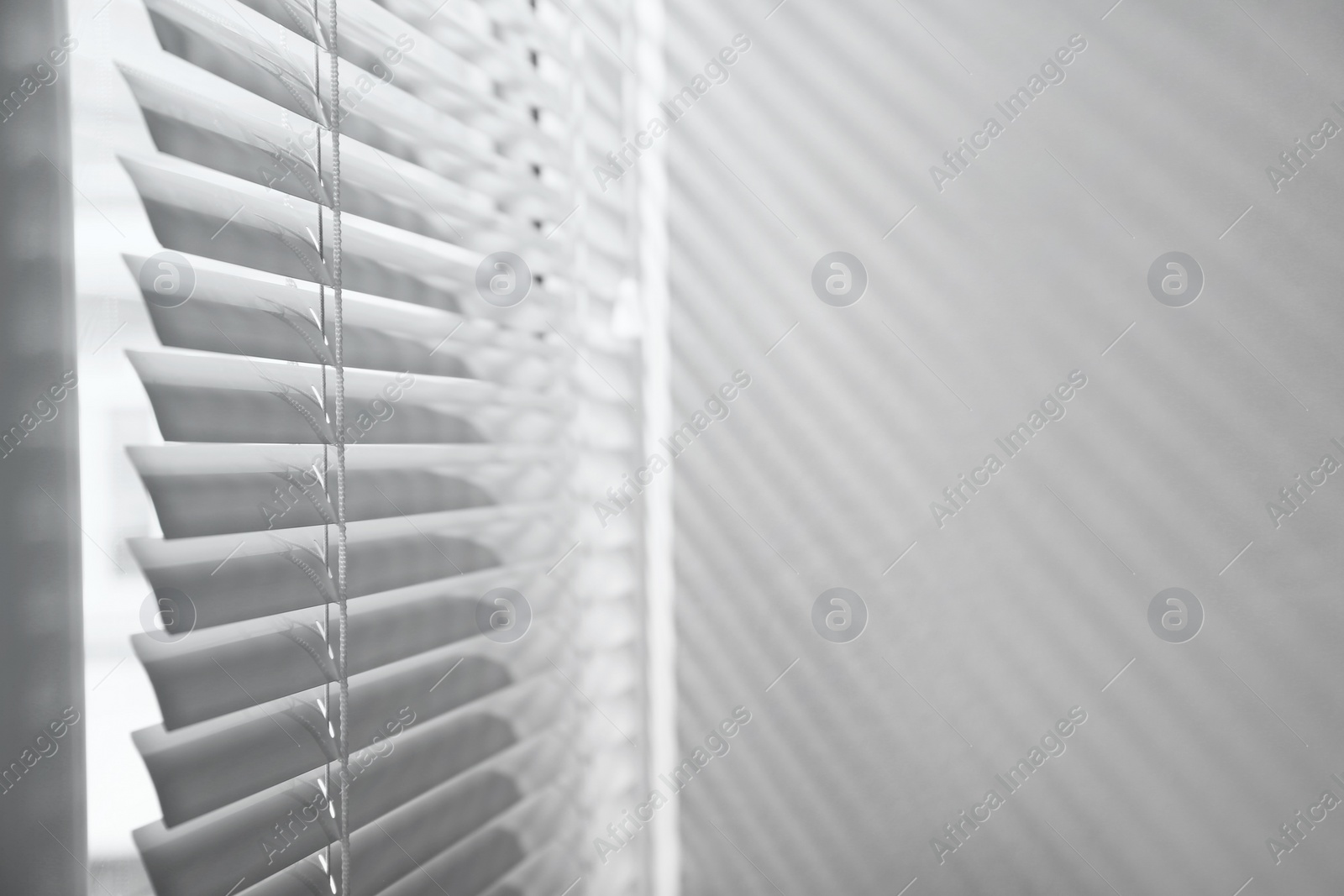 Photo of Window with closed horizontal blinds indoors. Space for text