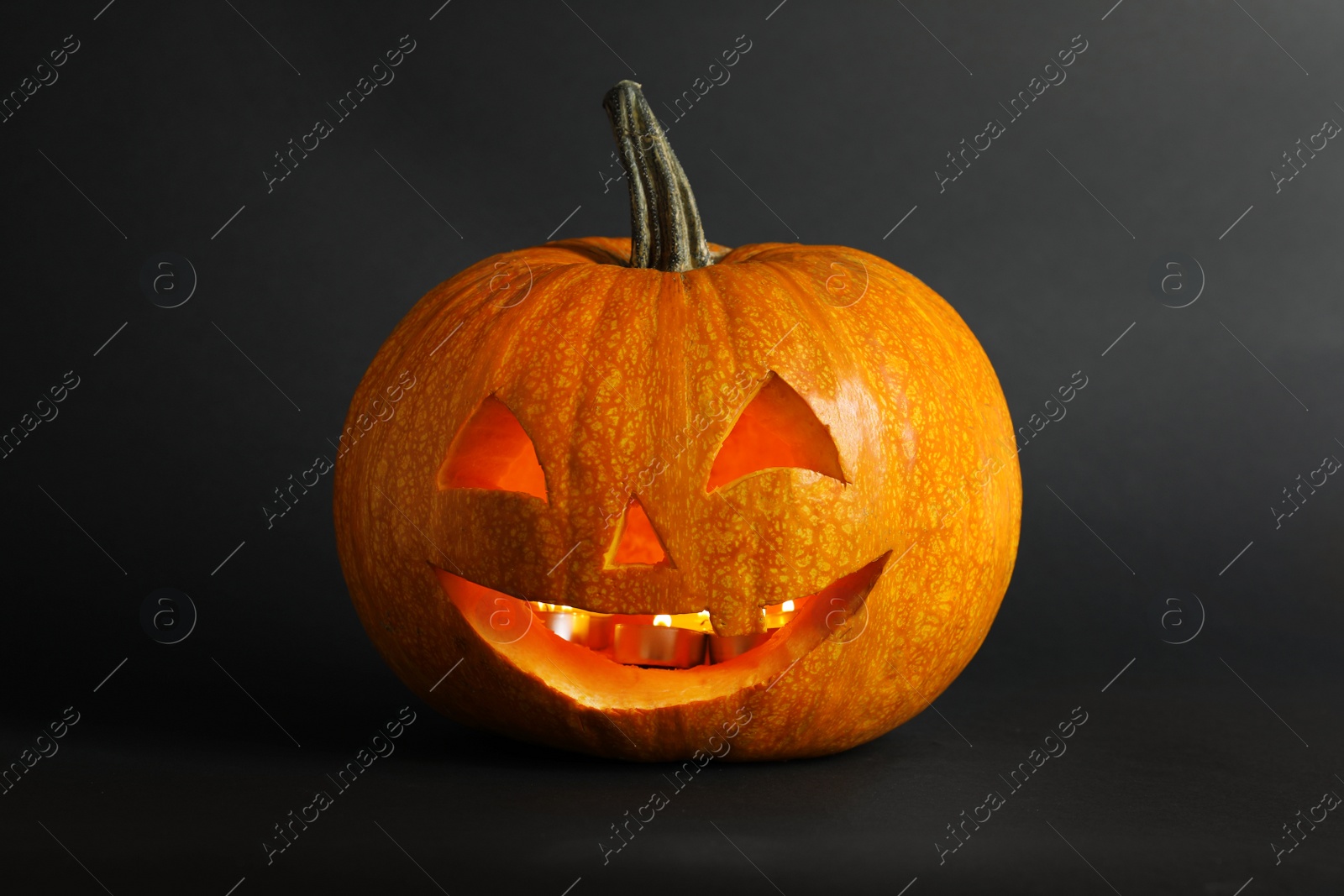 Photo of Halloween pumpkin head jack lantern on dark background