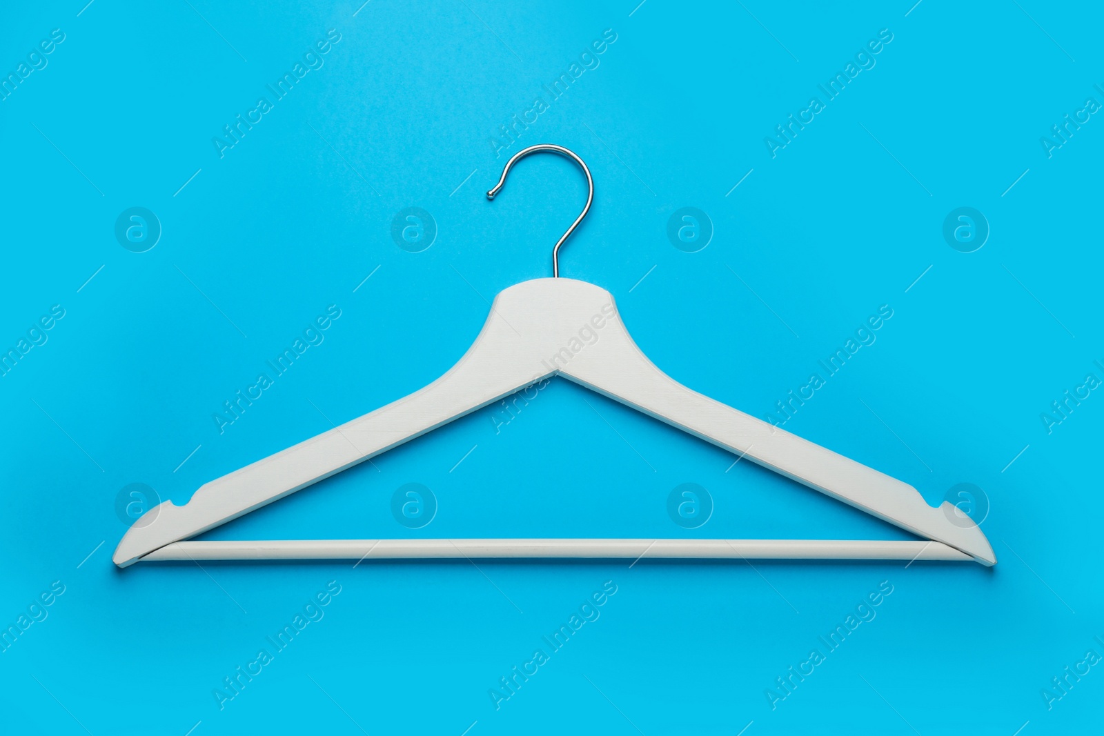 Photo of Empty wooden hanger on light blue background, top view