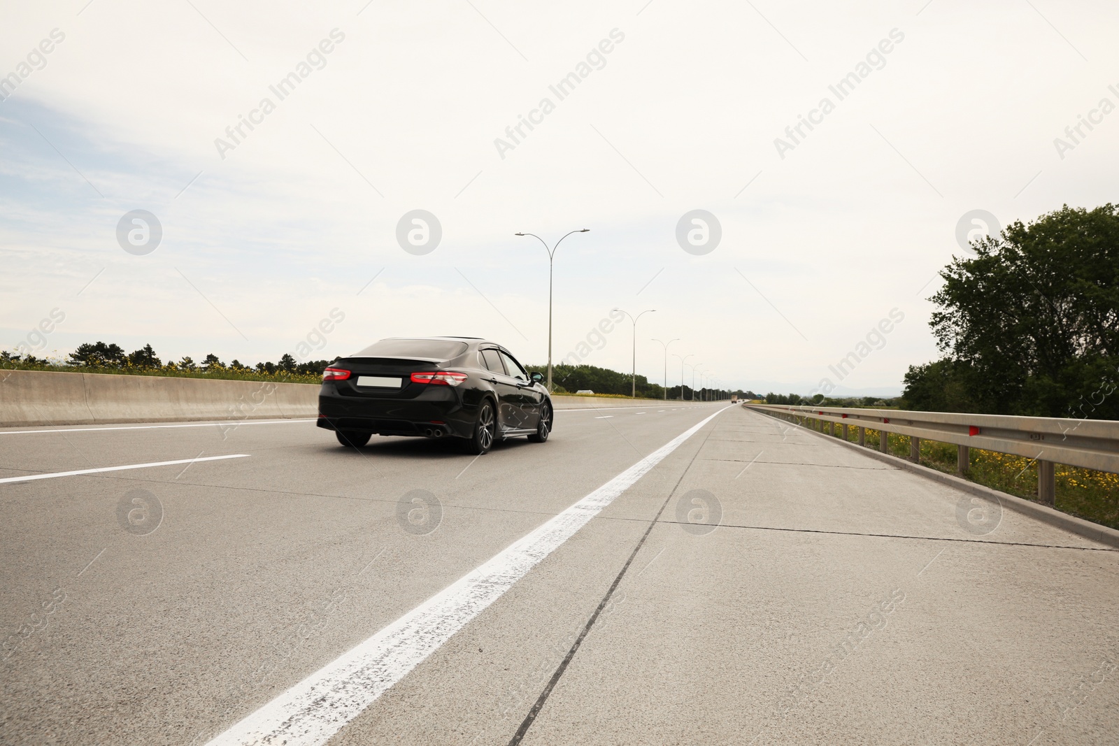 Photo of Picturesque view of asphalt road with car on cloudy day