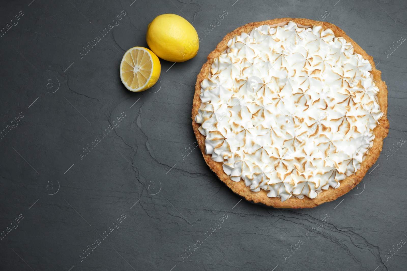 Photo of Flat lay composition with delicious lemon meringue pie on black table, space for text