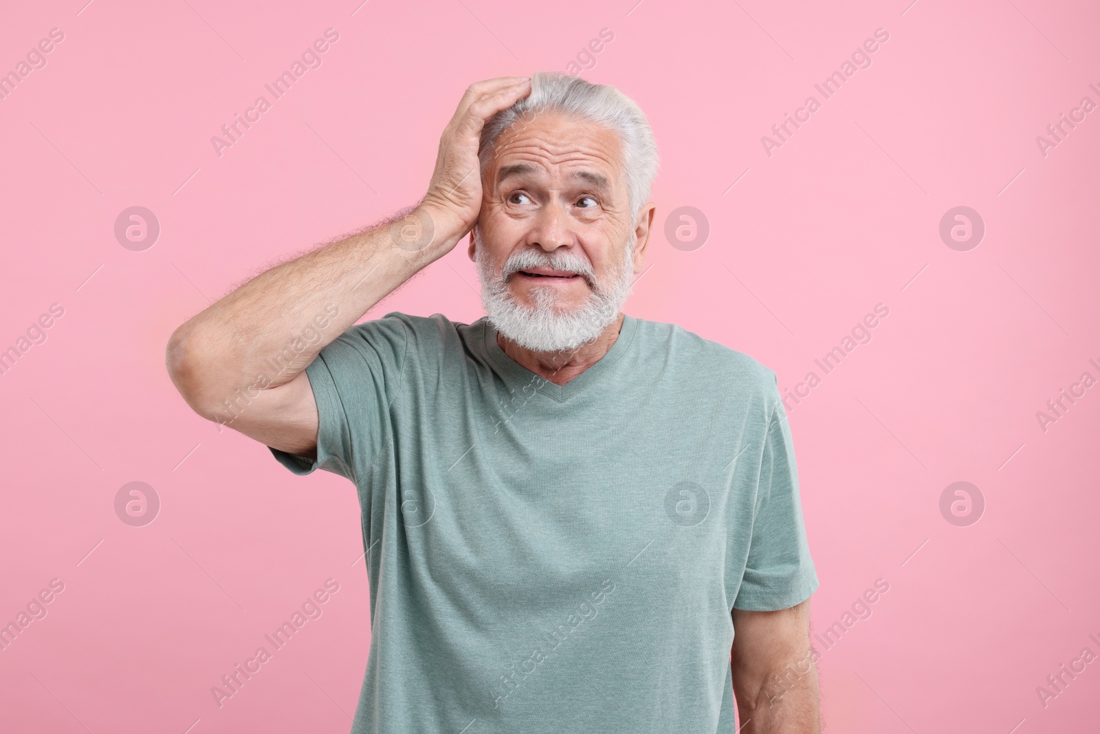 Photo of Portrait of embarrassed senior man on pink background