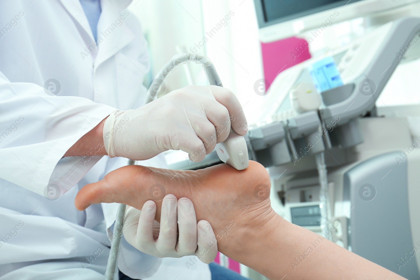 Photo of Doctor conducting ultrasound examination of patient's foot in clinic, closeup