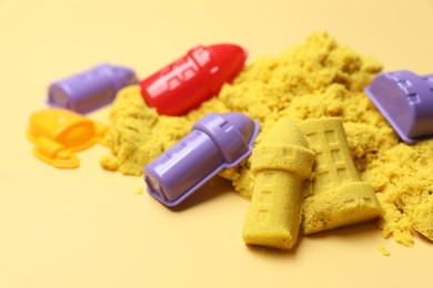 Photo of Castle figures made of kinetic sand and plastic toys on beige background, closeup. Space for text