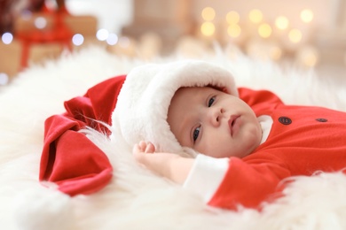 Cute baby in Christmas costume lying on fur rug