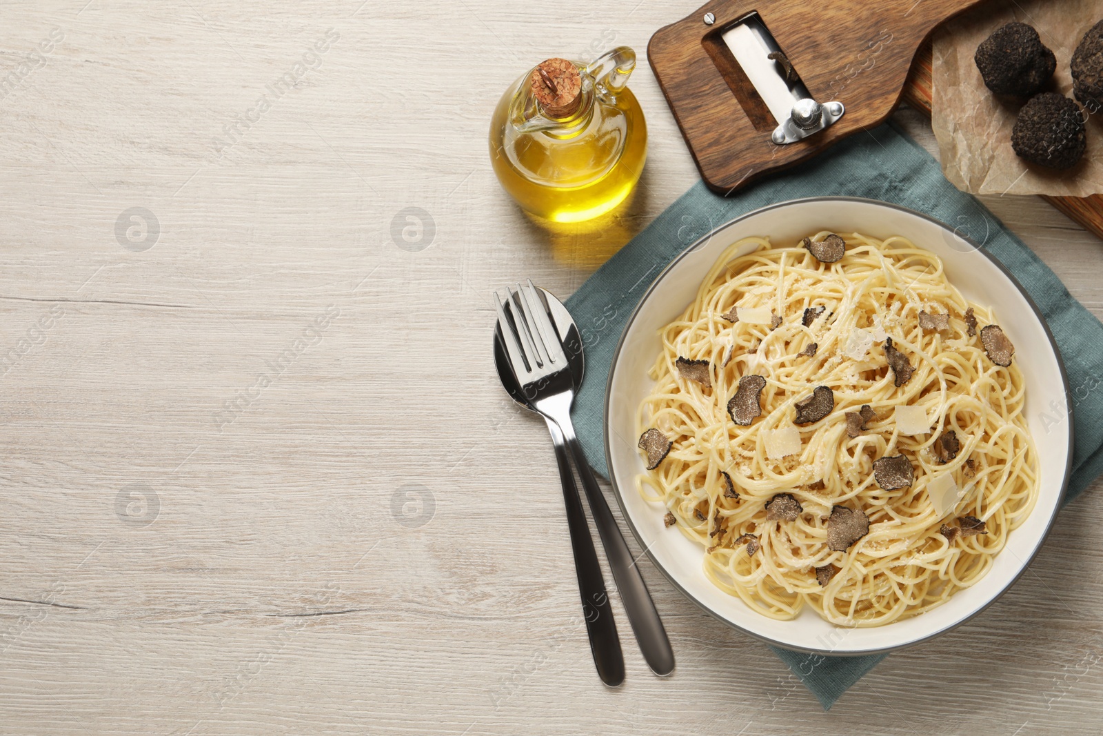 Photo of Tasty spaghetti with truffle served on wooden table, flat lay. Space for text