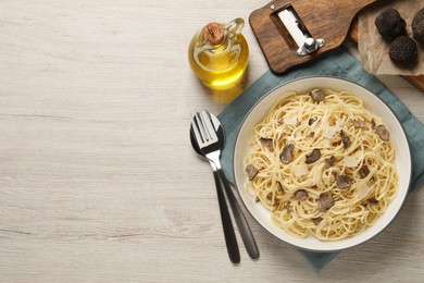 Photo of Tasty spaghetti with truffle served on wooden table, flat lay. Space for text