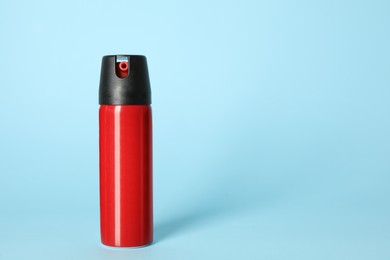 Photo of Bottle of gas pepper spray on light blue background. Space for text