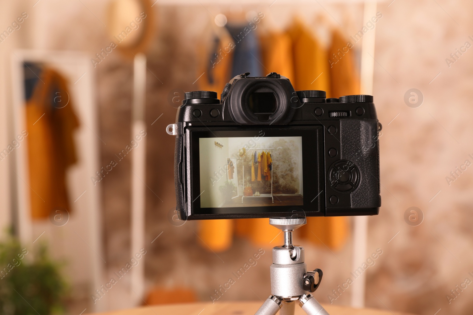 Photo of Taking photo of stylish clothes indoors, focus on camera